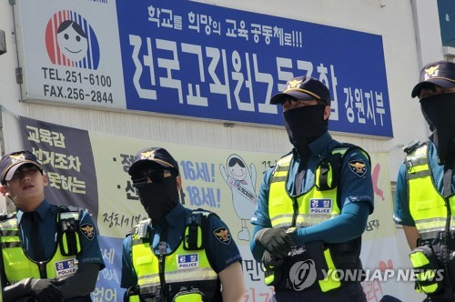 23일 강원 춘천시 전국교직원노동조합(전교조) 강원지부 앞에서 경찰 등 수사 당국이 압수수색을 위해 진을 치고 있다. 국가정보원은 이날 경찰청 국가수사본부와 합동으로 국가보안법 위반 혐의로 전교조 강원지부 소속 사무실과 신체, 차량 등 8건에 대한 압수수색을 진행 중이라고 밝혔다. [춘천=연합뉴스]